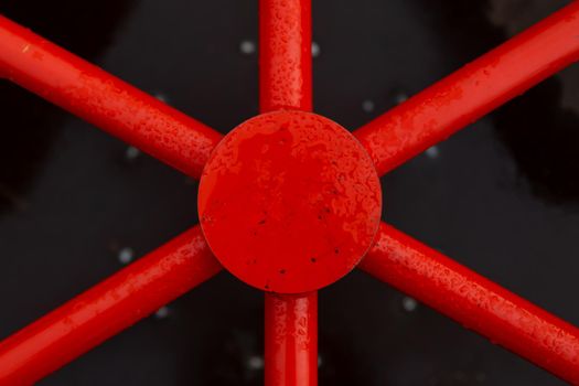 The red industrial part is similar to the steering wheel of a ship. Close up top view