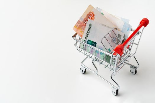 Toy shopping cart with Russian rubles money. Living wage and purchasing power concept