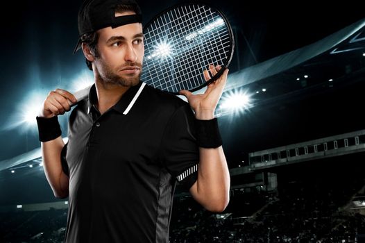 Tennis player with racket in black t-shirt. Man athlete playing on grand arena with tennis courts.
