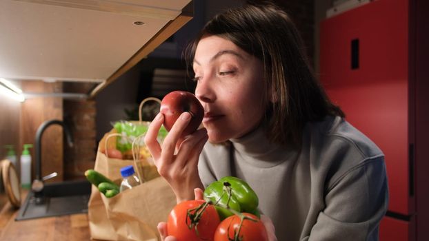 Lady smelling tomatoes and pepper