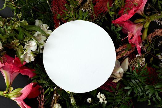 Bunch of fresh flowers arranged around white plate
