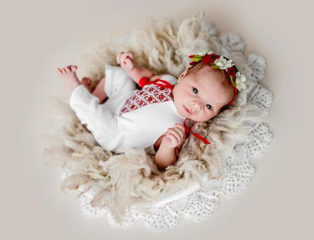 Sleepless newborn in embroidered suit and diadem