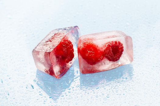 Ice cubes with frozen berries inside close up