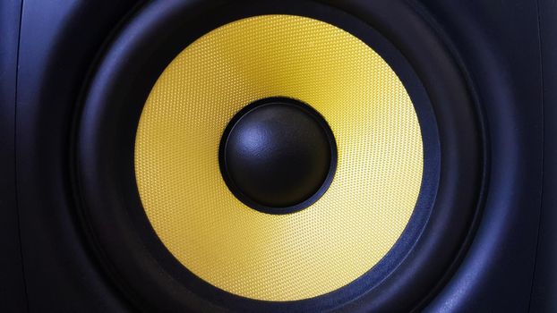 Speaker background. Woofer, yellow subwoofer close-up. Professional studio equipment. Vocal monitor for mixing and recording music. High quality desk monitors.