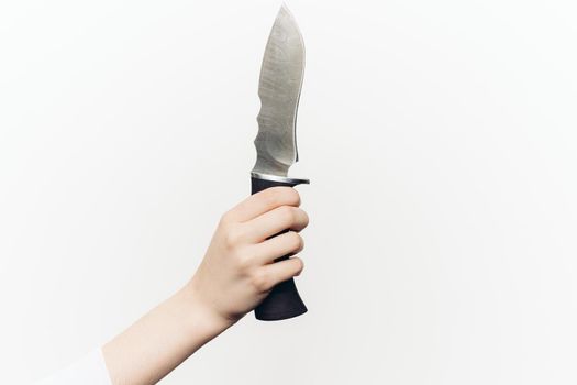 knife in hand close-up light background edged weapon
