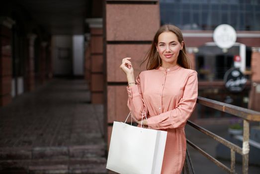 Beautiful woman in town holding shopping bag