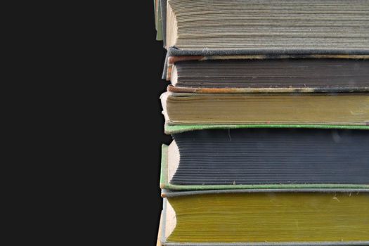 Pile of hardcover vintage books isolated with copy space. Black background. Close-up