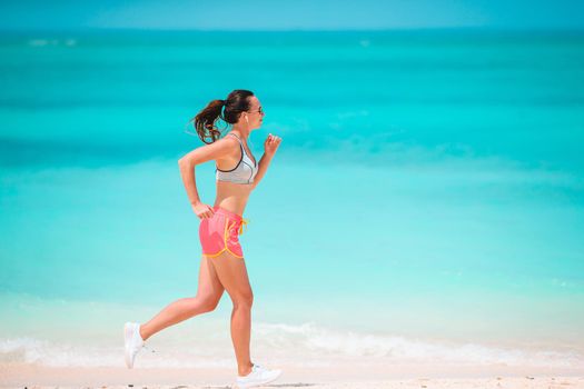 Fit young woman on the tropical beach in sportswear