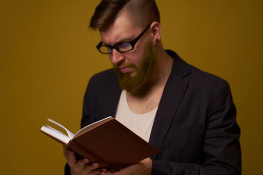 bearded man in a black jacket with a book in his hands education. High quality photo