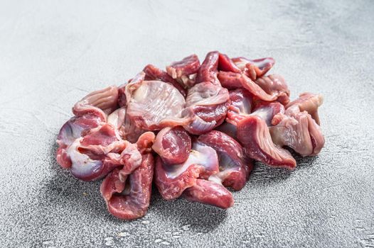 Raw uncooked chicken gizzards, stomach. Gray background. Top view