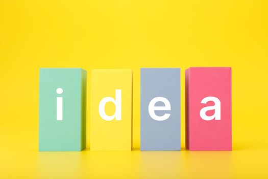 Creativity, innovation and idea concept. Single word idea written on multicolored rectangles on yellow background