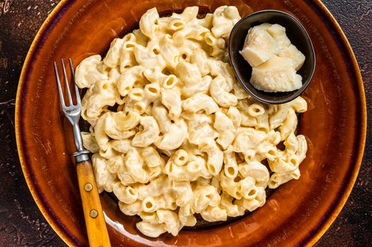 Macaroni Mac and cheese with Cheddar sauce in a plate. Dark background. Top view