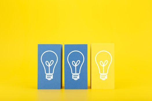 Creativity, brainstorming, innovation and fresh idea concept. Light bulbs on blue and yellow rectangles against yellow background