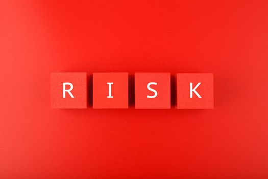 Risk single word written on red cubes against red background
