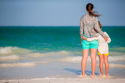 Beautiful mother and daughter at Caribbean beach enjoying summer vacation.