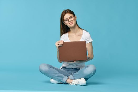 woman with laptop learning internet online education blue background. High quality photo