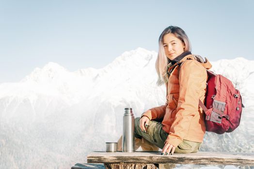 Explorer young woman resting in winter mountains.