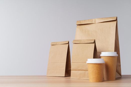 Paper bags with take away food and coffee cups containers