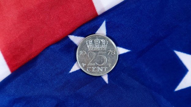 A 1 cent American dollar coin lies on the American flag. The currency is one cent over the flag of the United States.