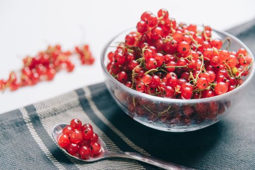 Red currant in a glass bowl on napkin.