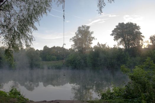 Beautiful landscape. Clear lake at morning fog.