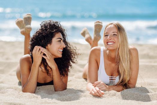 Two young women with beautiful bodies in swimsuit on a tropical beach
