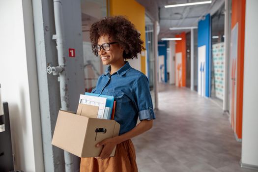Happy female employer walking around the office with documents