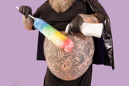 Fat man in hero suit sprays detergent onto brush on purple background