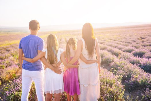 Family in lavender flowers field at sunset