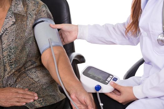 Female doctor measuring blood pressure of senior woman
