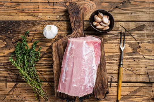 Raw pork loin with spices on wooden board. wooden background. Top view