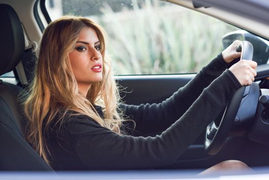 Blondie young woman driving a sport car