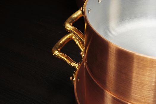 New copper cooking ware over dark background