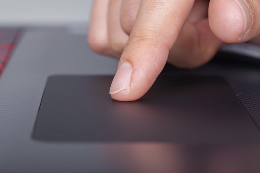 business hand working on a laptop touchpad