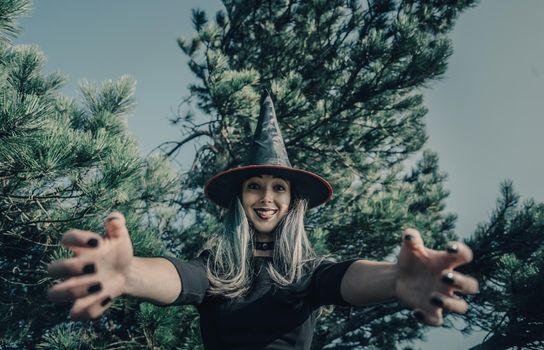 Scary witch in autumn forest