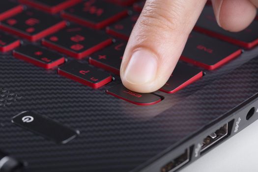 finger pushing esc button on laptop keyboard