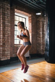 An athlete woman jumping on the spot in the gym