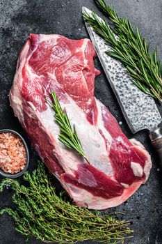Fresh Raw lamb mutton shoulder meat with butcher knife. Black background. Top view