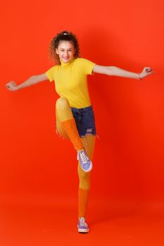 Girl in sports outfit jumping on one leg