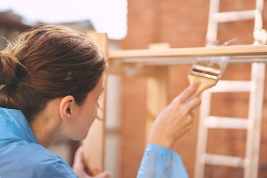 woman house painter renovating wood fittings at home