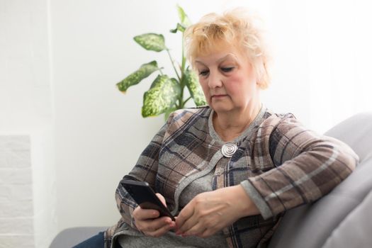 Senior woman reading message on smartphone