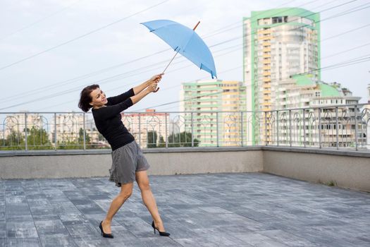 Woman is flying with umbrella, holding umbrella