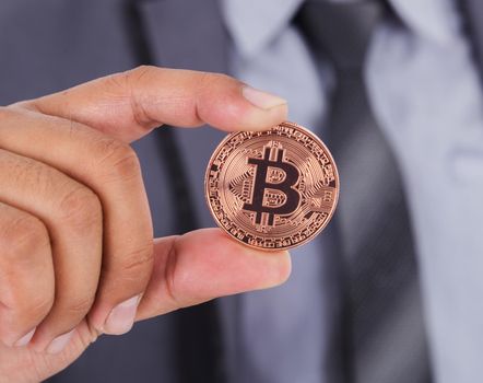 bronze bitcoin in hand of business man