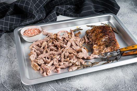 Texas bbq smoked puilled pork meat in a steel baking tray. White background. Top view