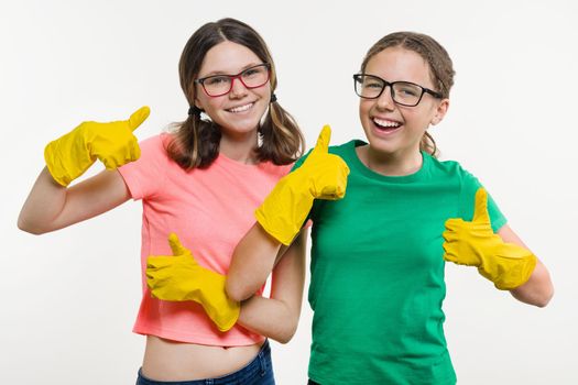 Girls teenagers wearing yellow protective gloves show thumbs up.