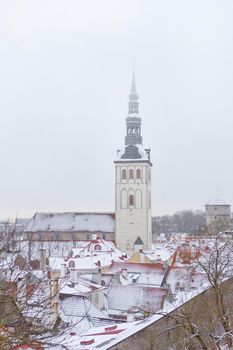 Old town of Tallinn in Estonia. Vertical photo of St. Nicholas Church, Niguliste facade and roofs of old town at winter time