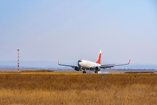 Passenger plane taking off from runway at airport on sunny day photo