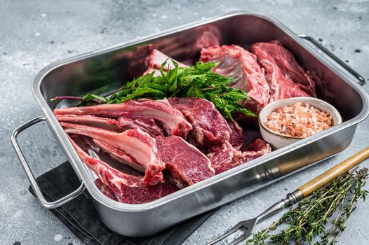 Uncooked Raw lamb, mutton chops in a steel kitchen tray. Gray background. Top view