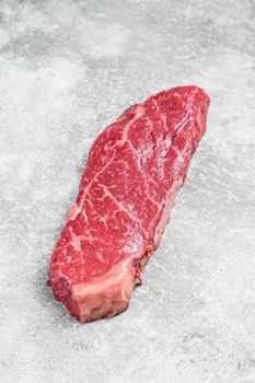 Raw Striploin steak, marbled beef. Gray background. Top view