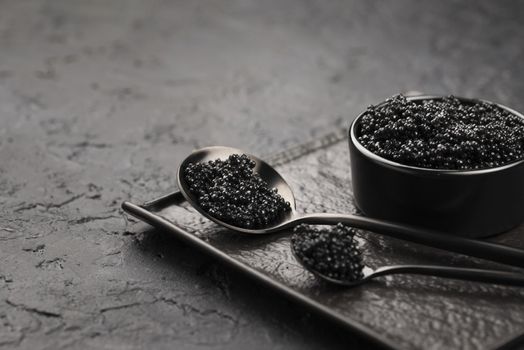 black caviar bowl with spoons ladle